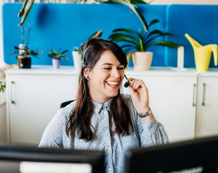 Smiling woman on phone behind desk