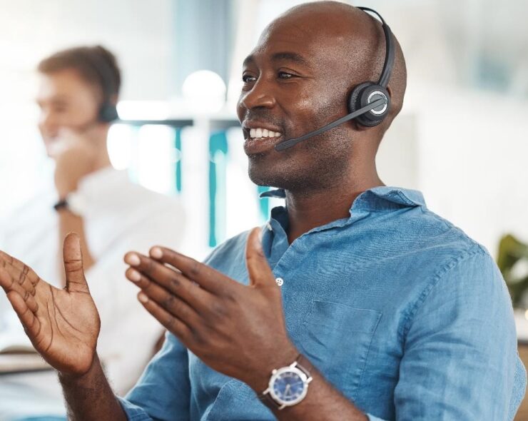 A man working in an office, talking into a headset.