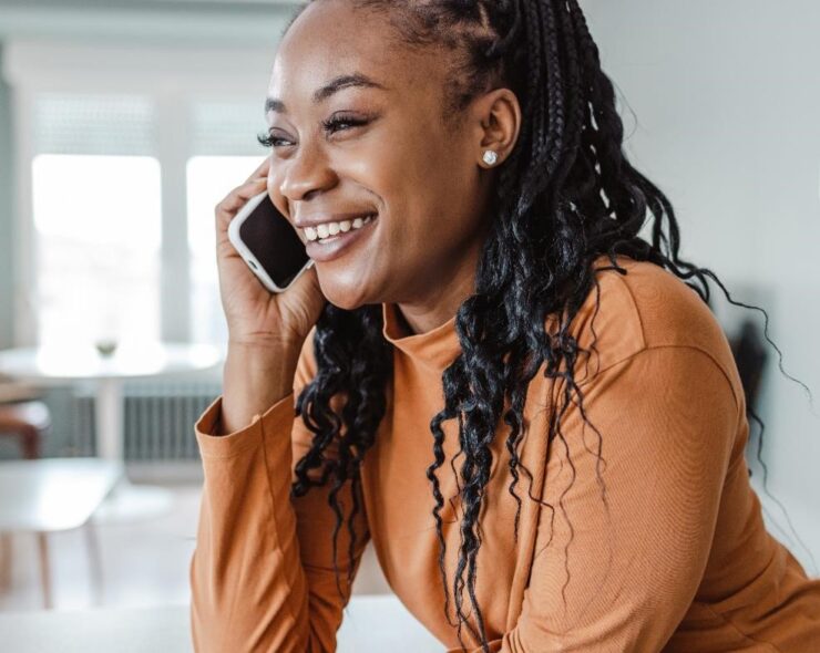 Cheerful young woman talking on the phone to her physician