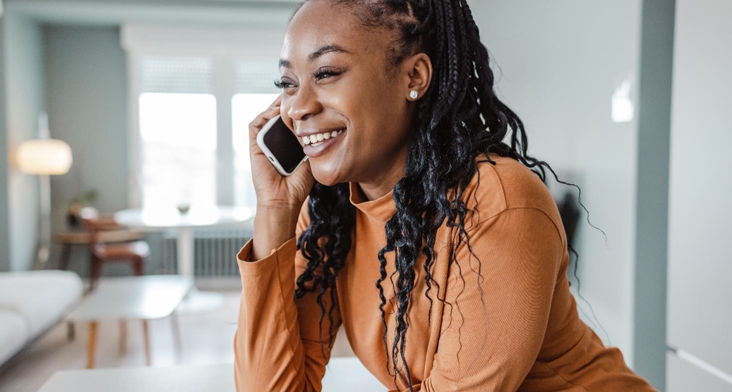 Cheerful young woman talking on the phone to her physician