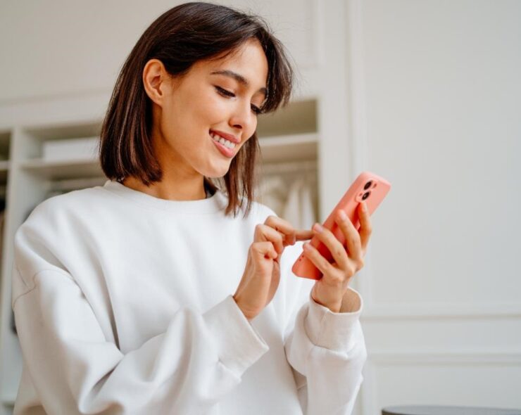 Young woman, looking at her phone, viewing her patient record