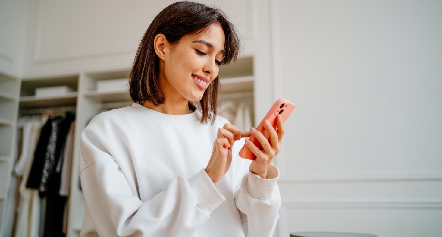 Young woman, looking at her phone, viewing her patient record