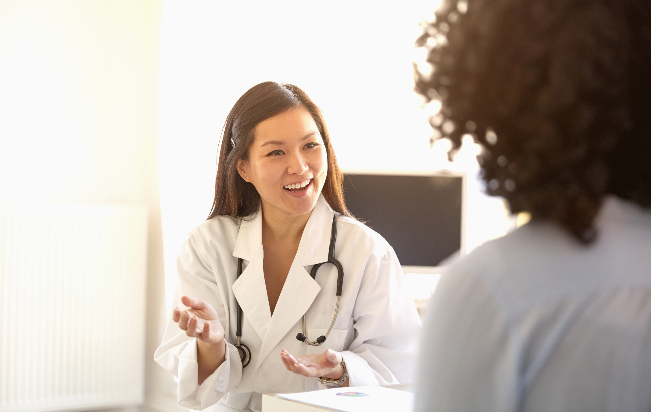 Doctor talking and gesturing to woman